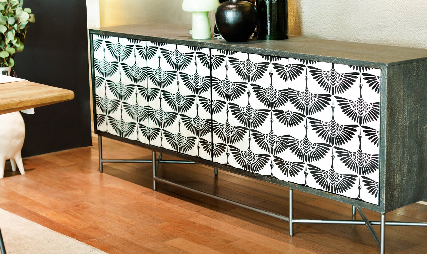 Modern console cabinet with black-and-white patterned doors, set on slim metal legs in a contemporary interior.